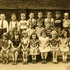 <p>Mrs. White’s first grade class in 1952 at the Agassiz School. The photograph was taken behind the C.B. Rogers Phamaracy on Burroughs Street.  Shown in each row from left to right are:</p><p>Rear row: (name not known), Peter Frikeisen,  (name not known), (name not known), Edward Foley, Charles Pitts, (name not known), Ronald Lukas, (name not known), George Marcella, and John (last name not known).</p><p>Middle row: Brian Baily, (other two names not known)</p><p>Front row: Judith Walsh, (name not known), Joanne  Platek, (next four names not known), Kathy Hourihan, Karen Hatch, Helen Burke, and (name not known).<br /><br />Photograph courtesy of Kathy Hourihan.</p><p> </p><p> </p><br/>