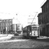 In this February 1938 view, car 5958 travels down Guild Row in Dudley Square. Although difficult to see without enlargement, signs in the square advertise "General Self Service Food Store", "Roxbury Hat Shop", "Roxbury Employment Center", "Roxbury Tavern", and "India Pale Ale." Other signs advertise a barber shop, auto supplies, and a key-making service.