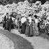 This photograph is an enlarged portion of another photograph appearing on this site. Visitors to the Arnold Arboretum at the turn of the century pass by a display of mountain laurel.
