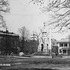 This view of Monument square about 1905 shows men in bowler hats, a street car, the Loring-Greenough House, a watering trough, and the apartment building at the corner of Greenough Avenue. Note the unpaved streets.